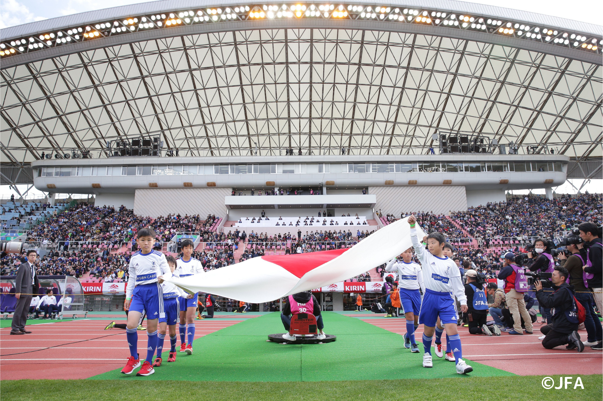 日本の国旗を持って入場する子どもたち